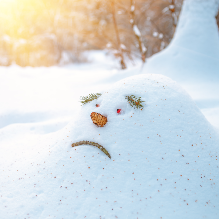 Mound of snow with sad snowman face