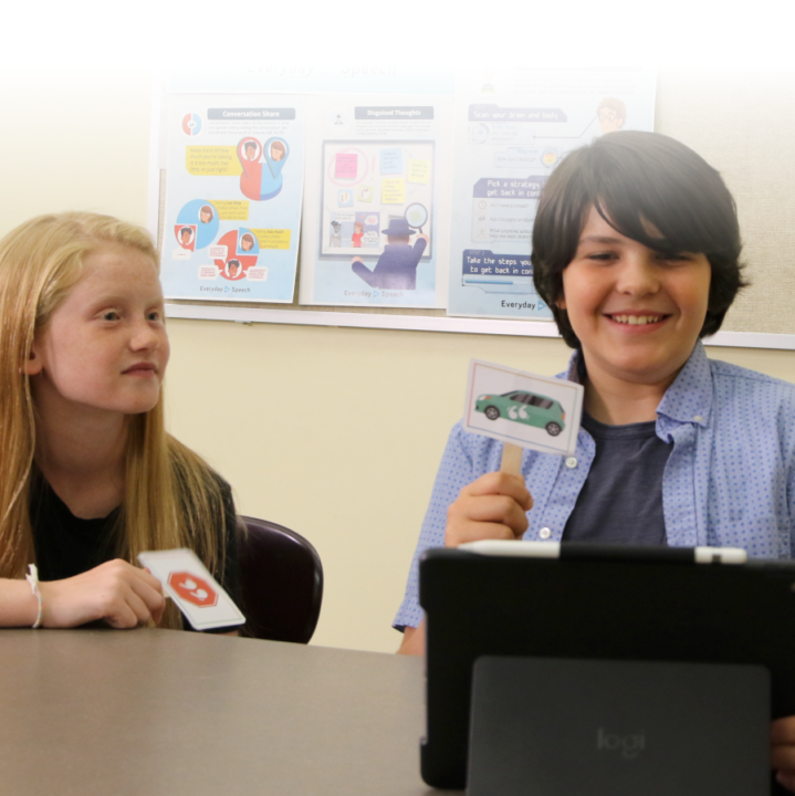 boy and girl student holding up cards with pictures