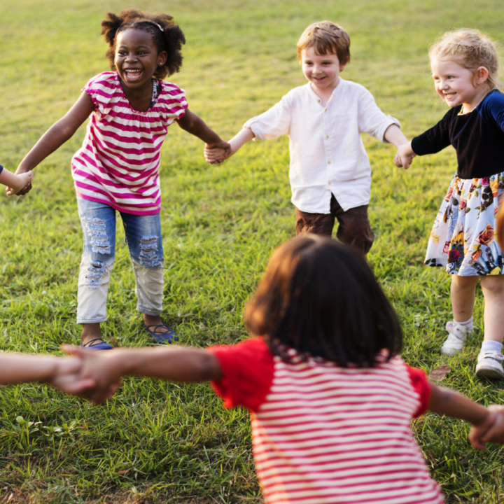 kids holding hands outside in a circle