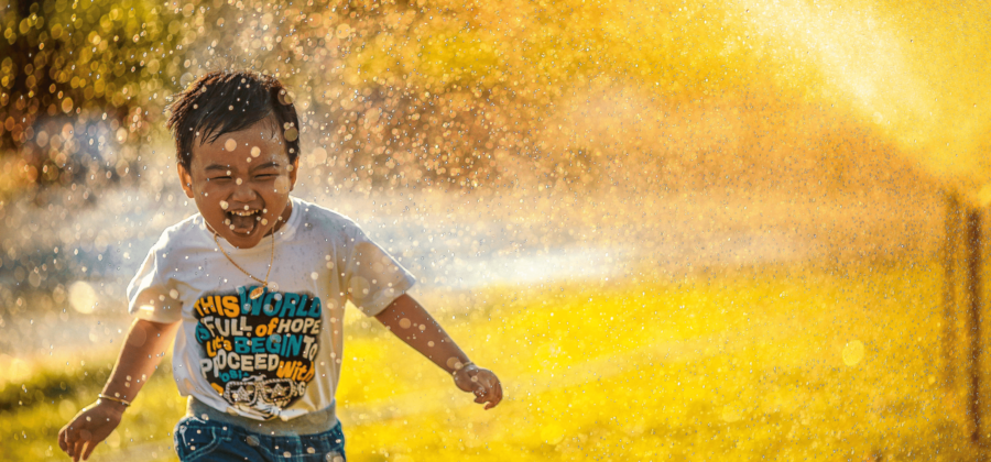 kid running through sprinkler